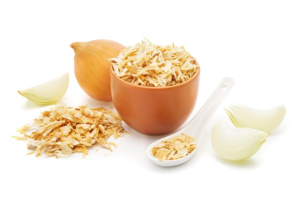 Dried onions in a white ceramic spoon, chopped fresh onion  isolated on white background closeup